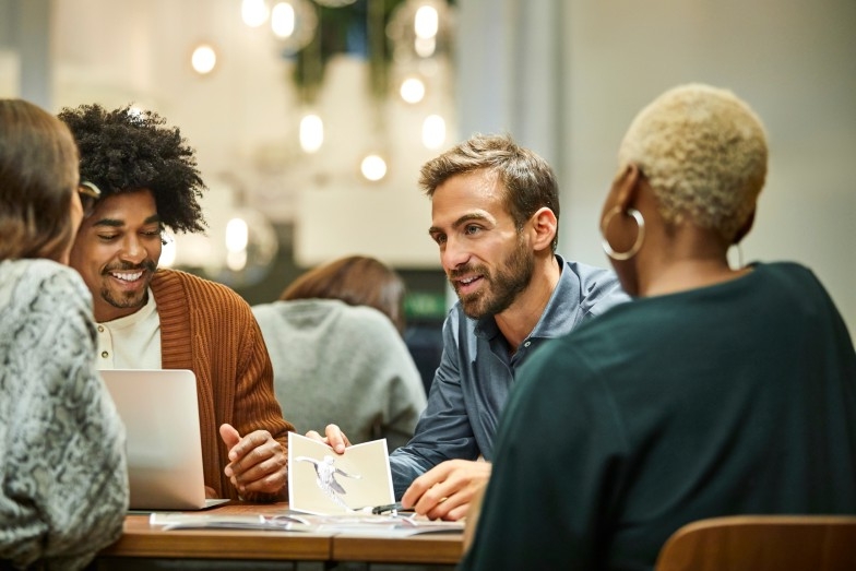 happy group of people working together around a table 
