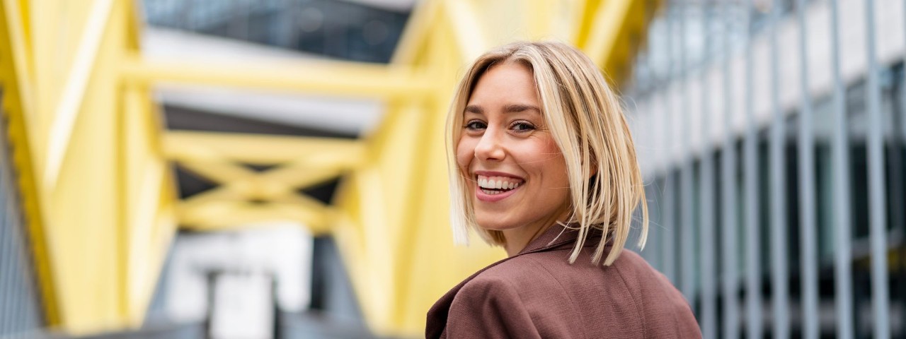 smiling-young-person-walking-over-a-bridge